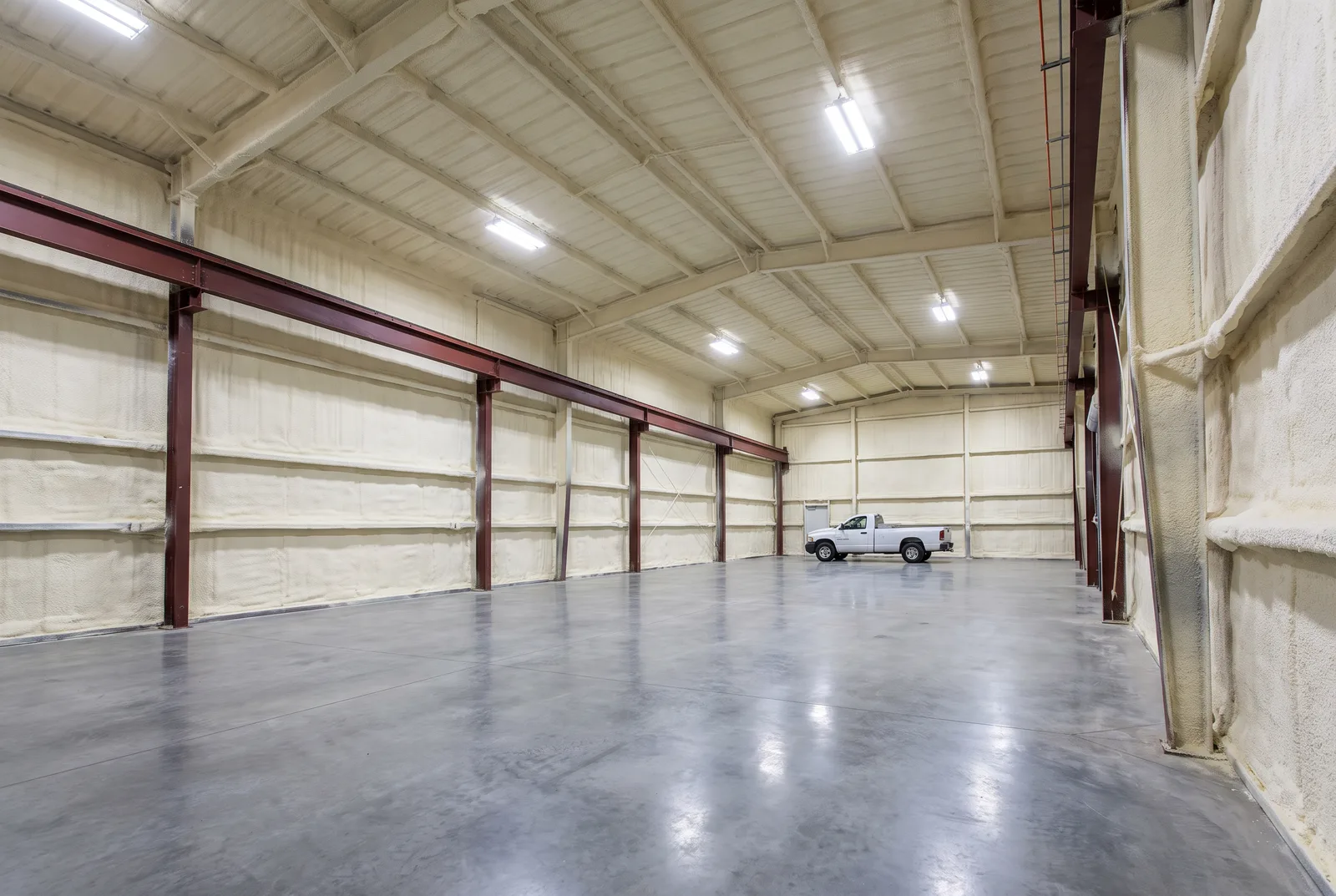 Steel building interior with spray foam coating the roof and walls